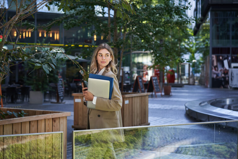 beautiful smiling woman dressed corporate suit holding laptop documents smiling camera